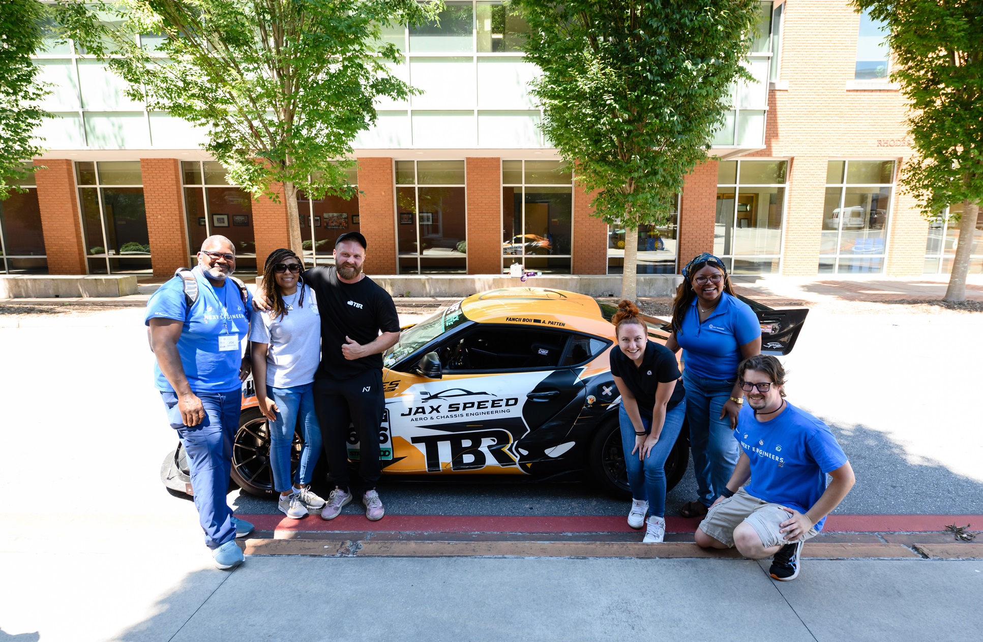 Camp facilitators with race car